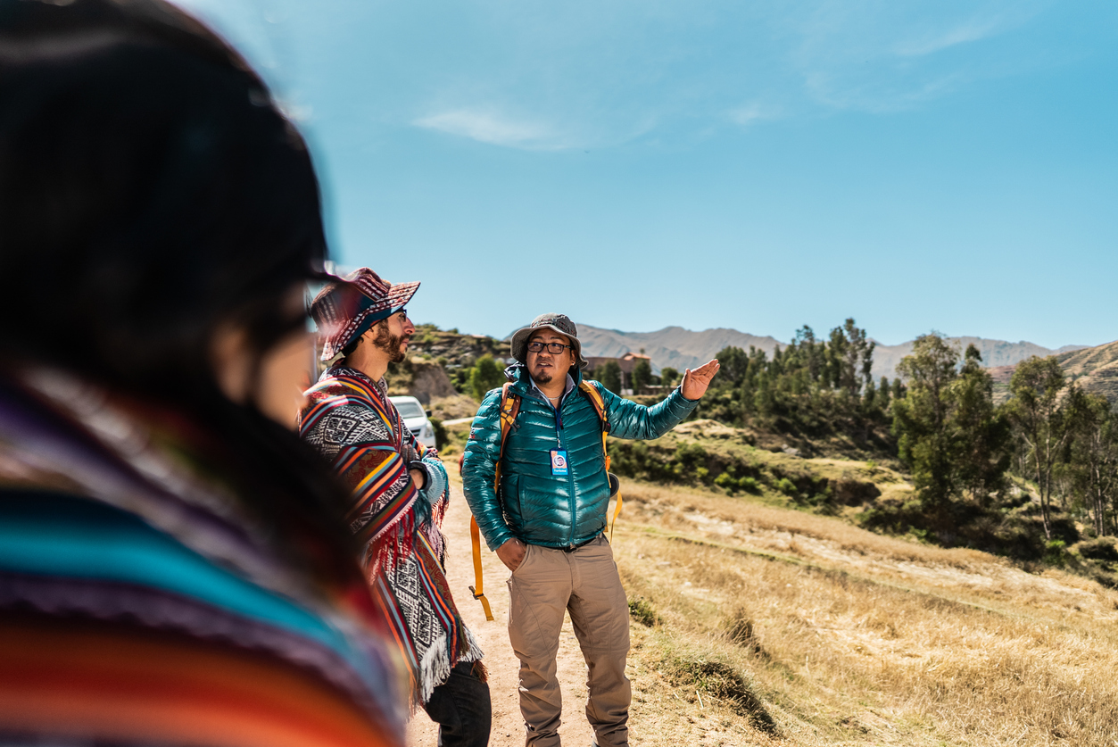 Tour guide talking with tourists on a mountain, in Moray, Peru
