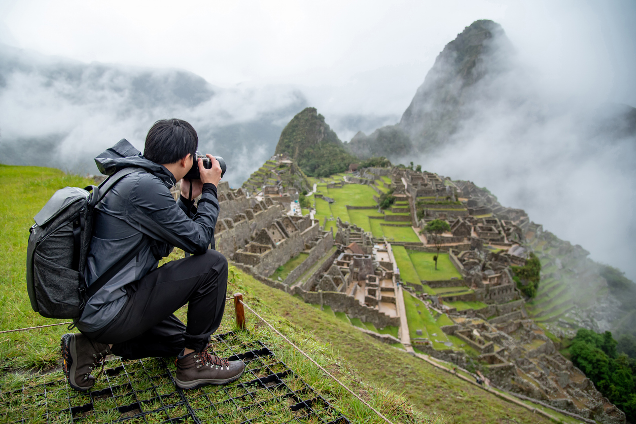 Asian man tourist taking photo at Machu Picchu