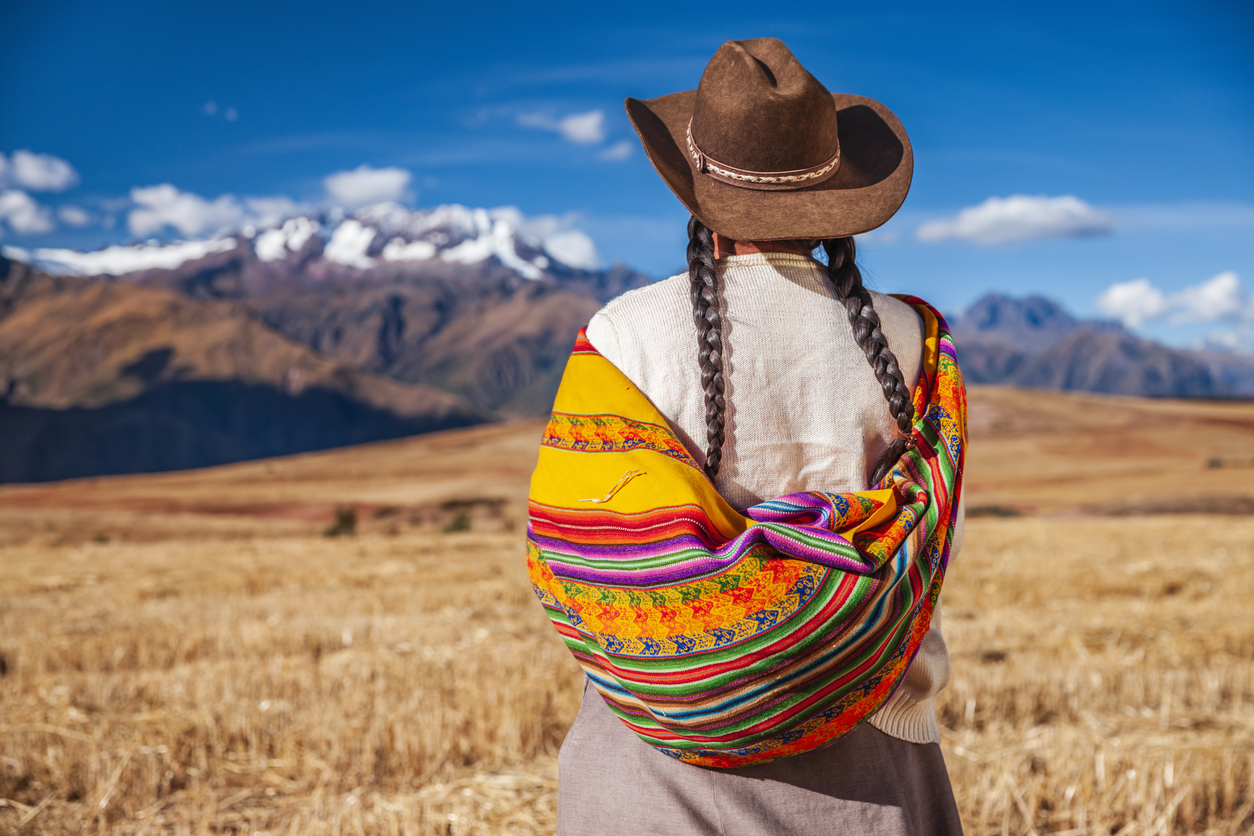 Peruvian woman in national clothing looking at Andes, The Sacred Valley