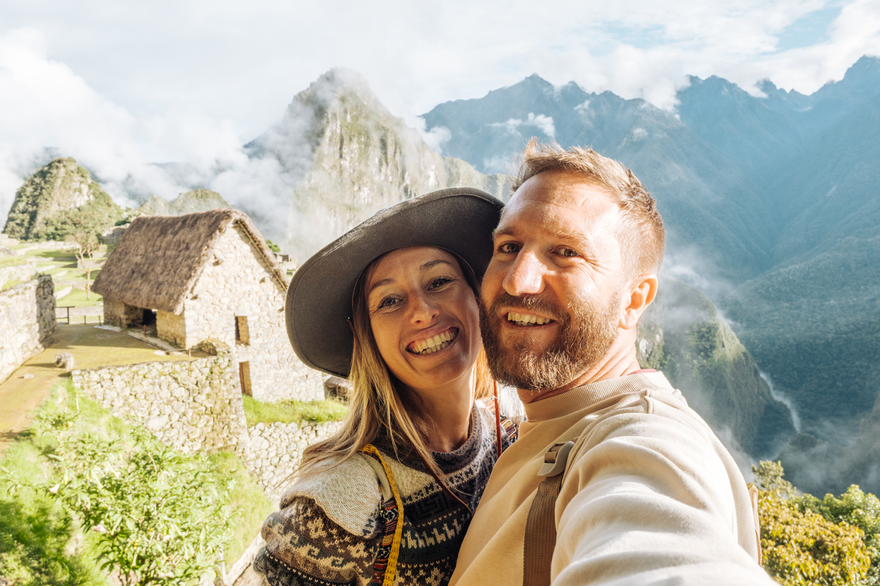 Couple Taking Selfie at Machu Picchu with Mountainous Backdrop