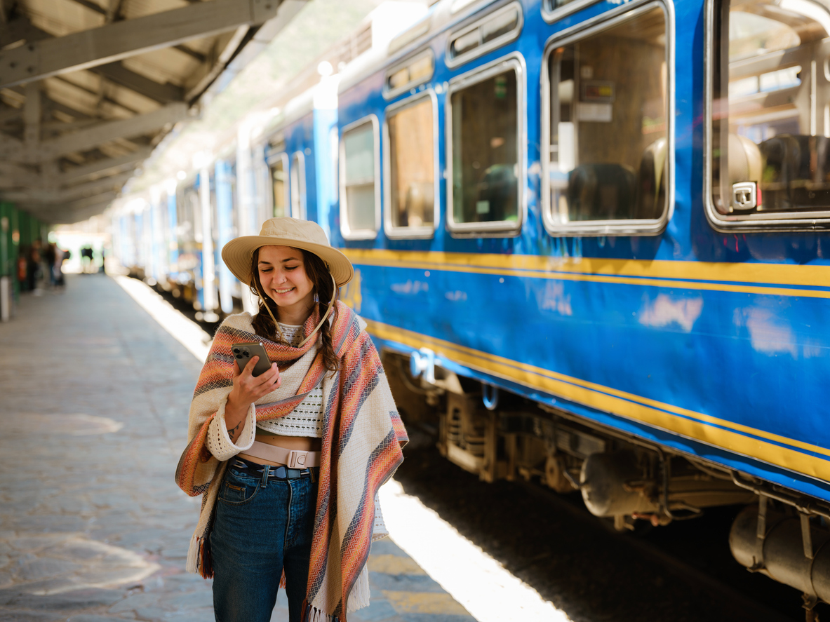 Woman using smartphone boarding the train to Machu Picchu