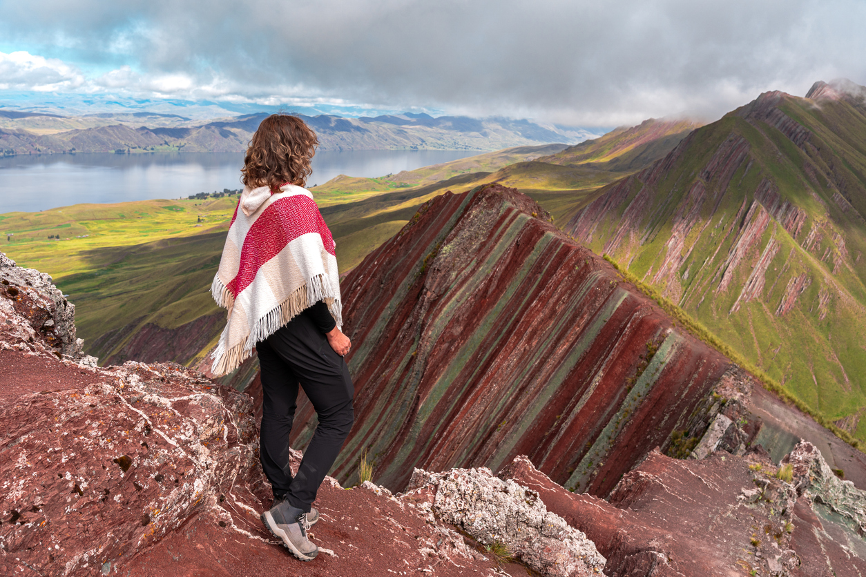 Female traveler admiring the layered rock formations and landscape of Pallay Punchu mountains, Peru